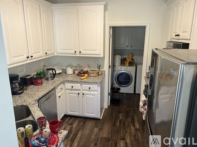 A kitchen with white cabinets and a wooden floor.