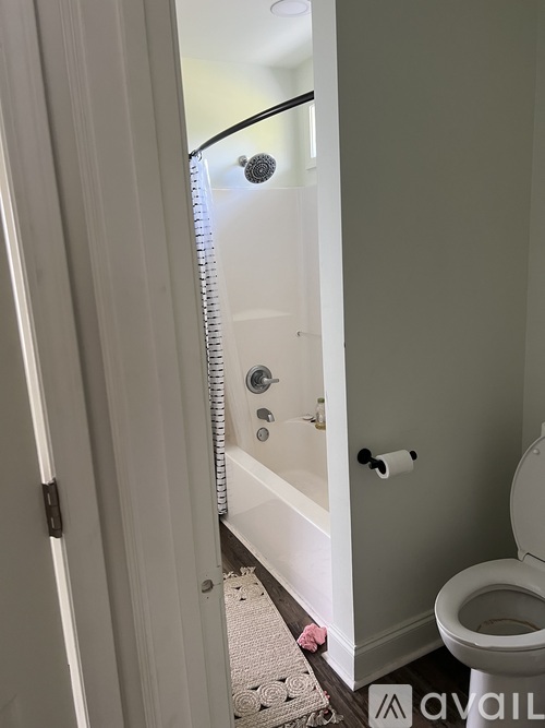 A bathroom with a toilet, a bathtub and a door.