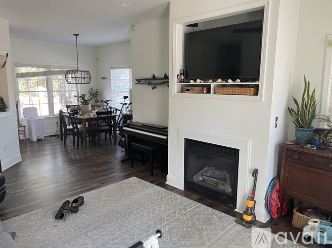 A living room with a fireplace and a television on the wall.