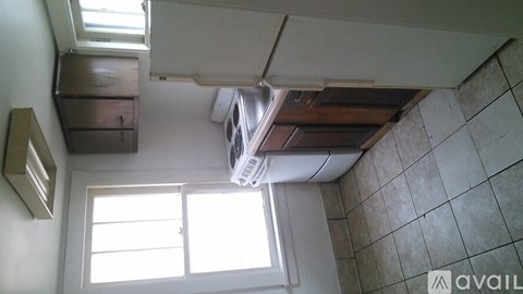 A small room with a window and a fan.