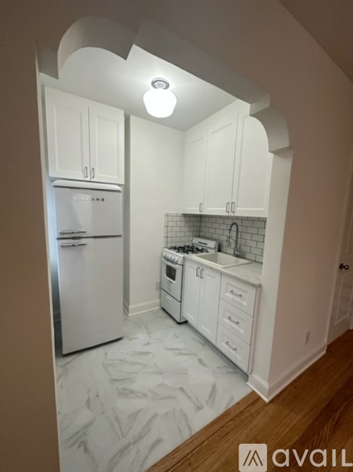 A kitchen with white cabinets and appliances.