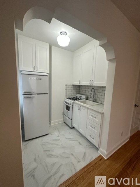A kitchen with white cabinets and appliances.