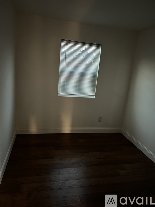 A room with a window and wooden floors.