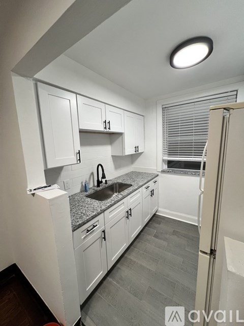 A kitchen with white cabinets and a granite countertop.