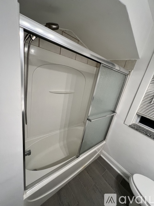 A white bathroom with a walk-in shower and a toilet.