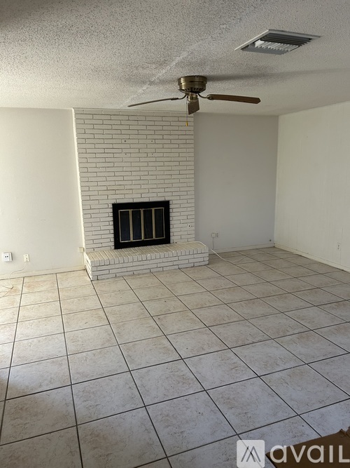 A room with a fireplace and a ceiling fan.