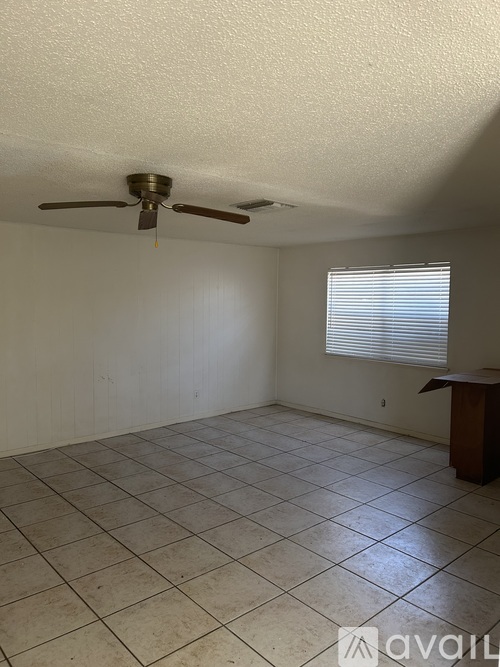A room with a ceiling fan and tiled floor.
