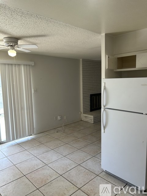 A white refrigerator in a kitchen with a ceiling fan.