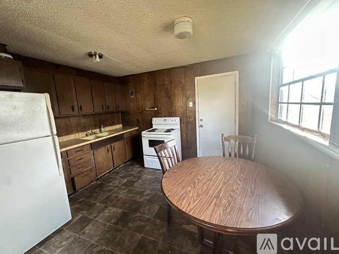 A kitchen with a table and chairs in the middle of the room.