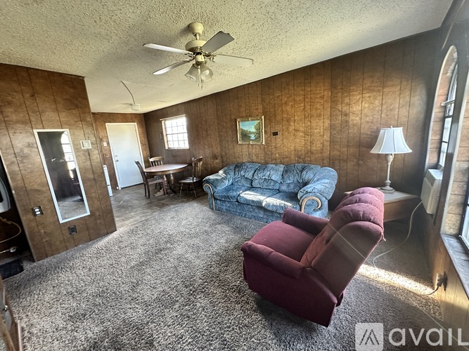 A living room with a blue couch and a red chair.