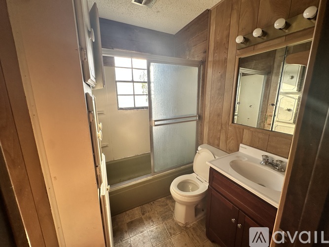A bathroom with a toilet, sink, and mirror.