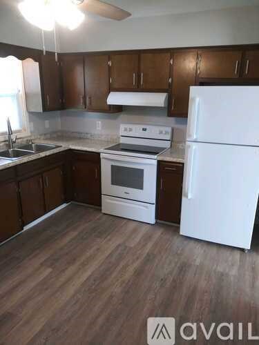 A kitchen with a white refrigerator, stove, and oven.