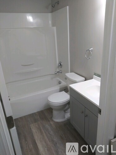 A white toilet sits in a bathroom next to a sink.