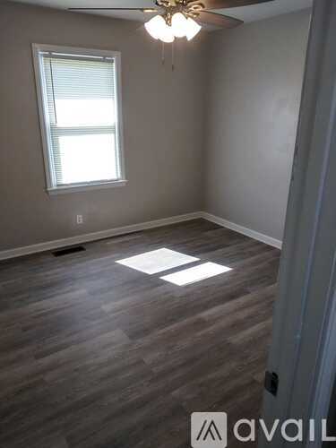 A room with a ceiling fan and a window.