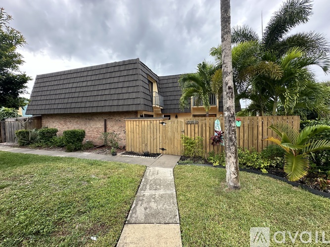 A house with a grey roof and a wooden fence.