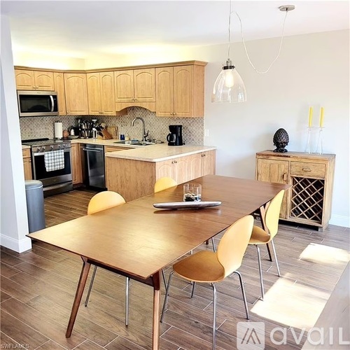A kitchen with a table and chairs in the foreground.