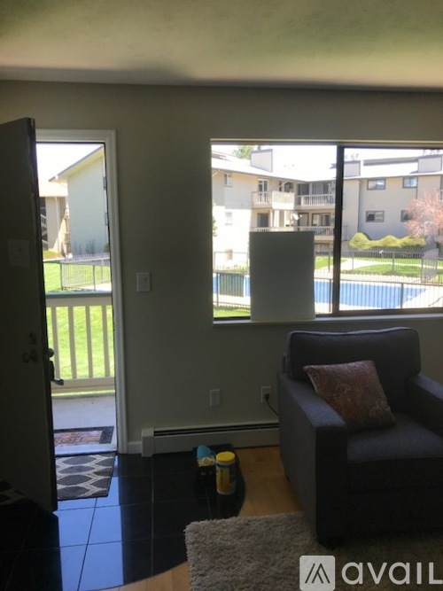 A living room with a couch and a door leading to a balcony.