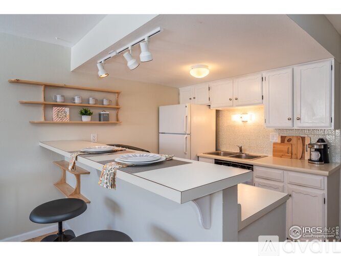 A kitchen with white cabinets and a white countertop.
