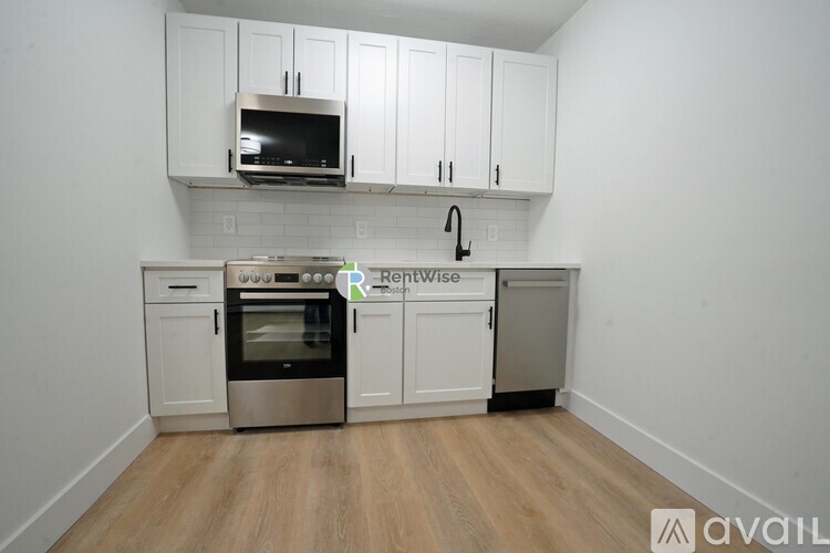 A kitchen with white cabinets and a stainless steel oven.