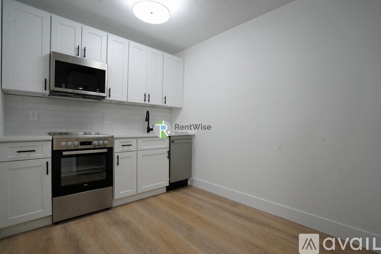 A kitchen with white cabinets and a stainless steel oven.