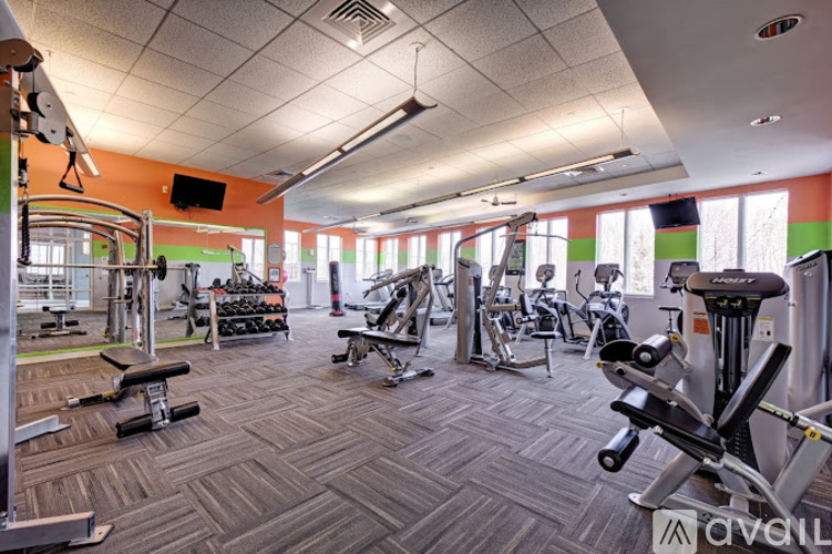 A gym with a variety of equipment including treadmills, weights, and exercise machines.