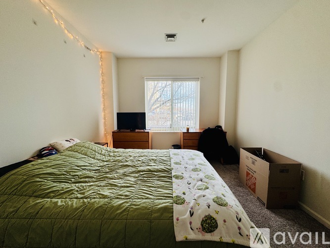 A bedroom with a bed, a dresser, and a window.