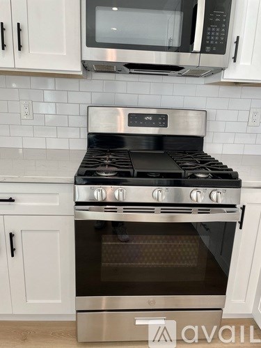 A modern kitchen with a stainless steel oven and microwave above it.