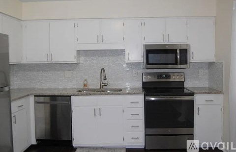 A kitchen with white cabinets and a granite countertop.