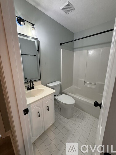 A bathroom with a toilet, sink, and bathtub.