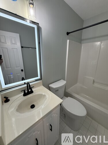 A bathroom with a toilet, sink, and bathtub.