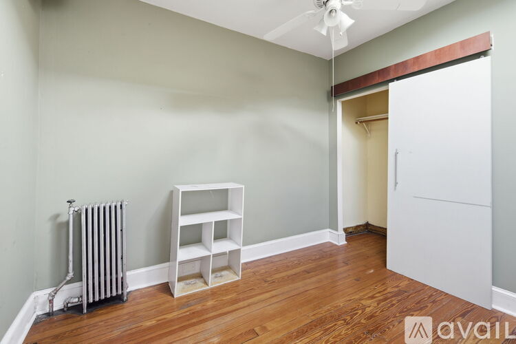 A room with a radiator and a shelf unit.