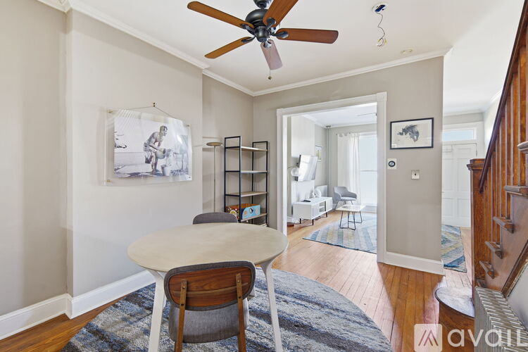 A dining room with a table and chairs and a ceiling fan.