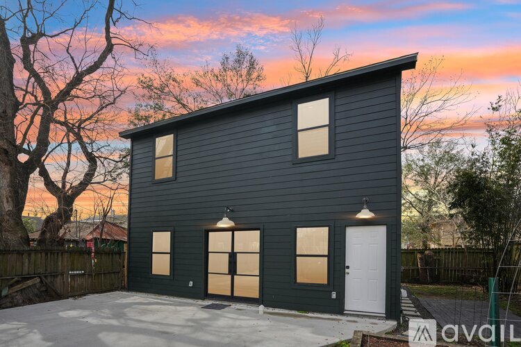A house with a dark grey exterior and a white door is available for purchase.