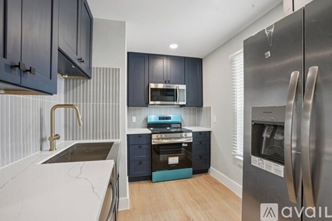 A kitchen with dark cabinets and a stainless steel refrigerator.