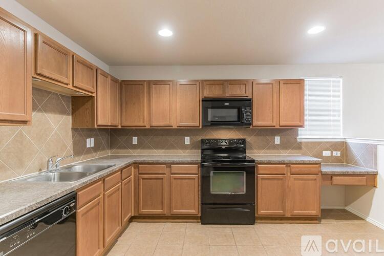 A kitchen with wooden cabinets and black appliances.
