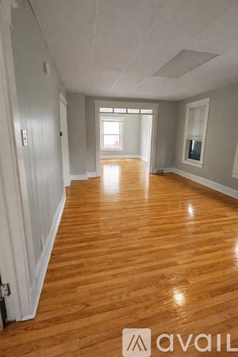 A long hallway with wooden floors and white walls.