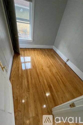 A room with wooden flooring and a window.