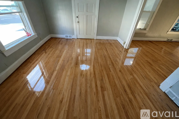A room with wooden flooring and a white door.