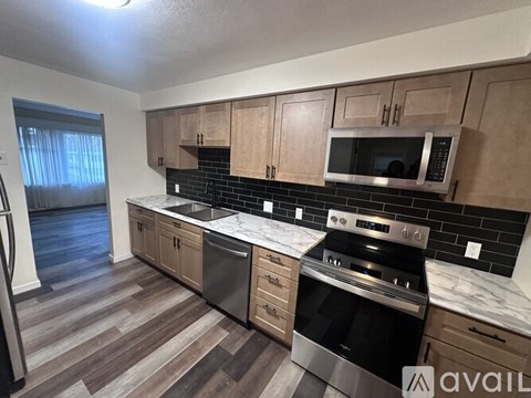 A kitchen with wooden cabinets and black appliances.