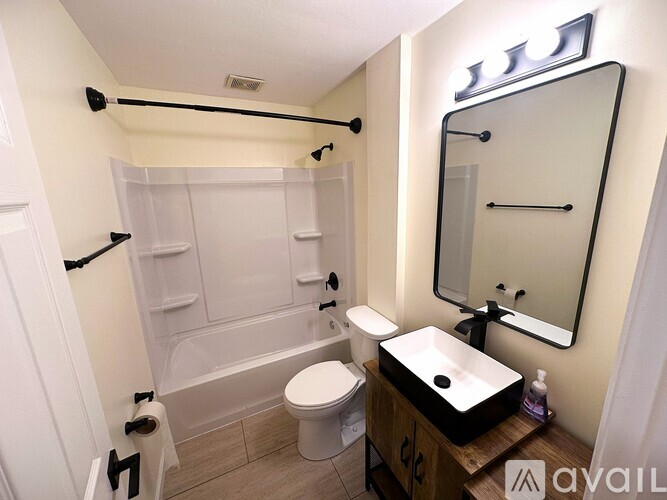 A bathroom with a toilet, sink, and bathtub.