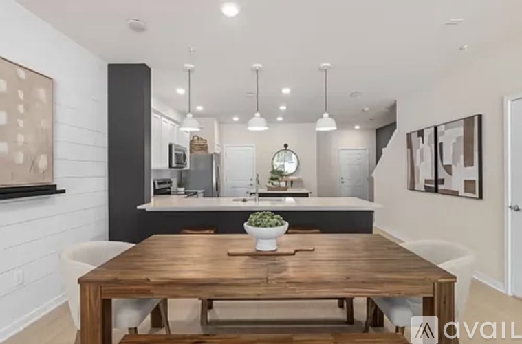 A modern kitchen with a wooden dining table and chairs.