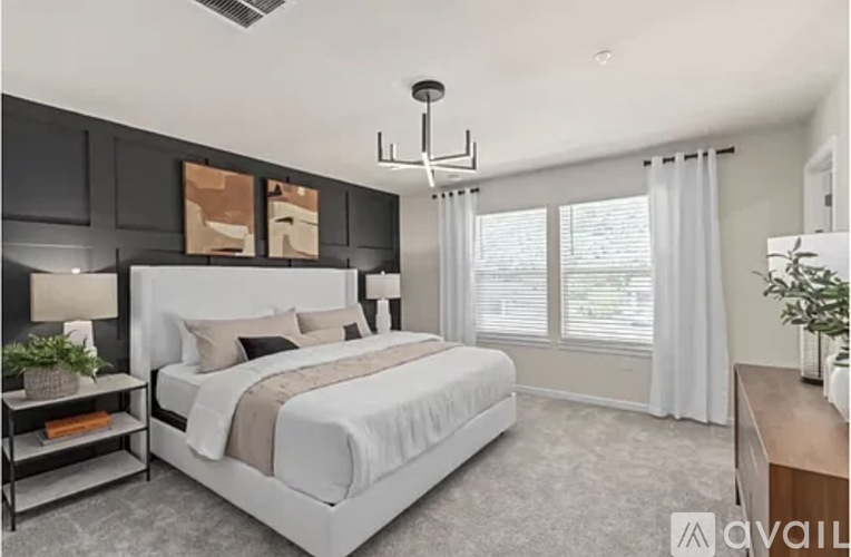 A bedroom with a large bed and a ceiling fan.