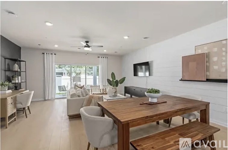 A modern dining room with a wooden table and chairs.