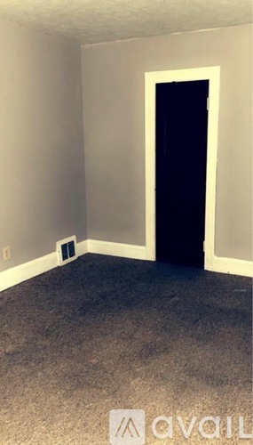 A room with a carpeted floor and a door.