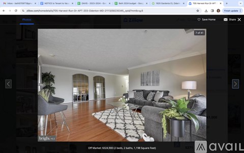 A modern living room with a grey sofa and a black and white patterned rug.