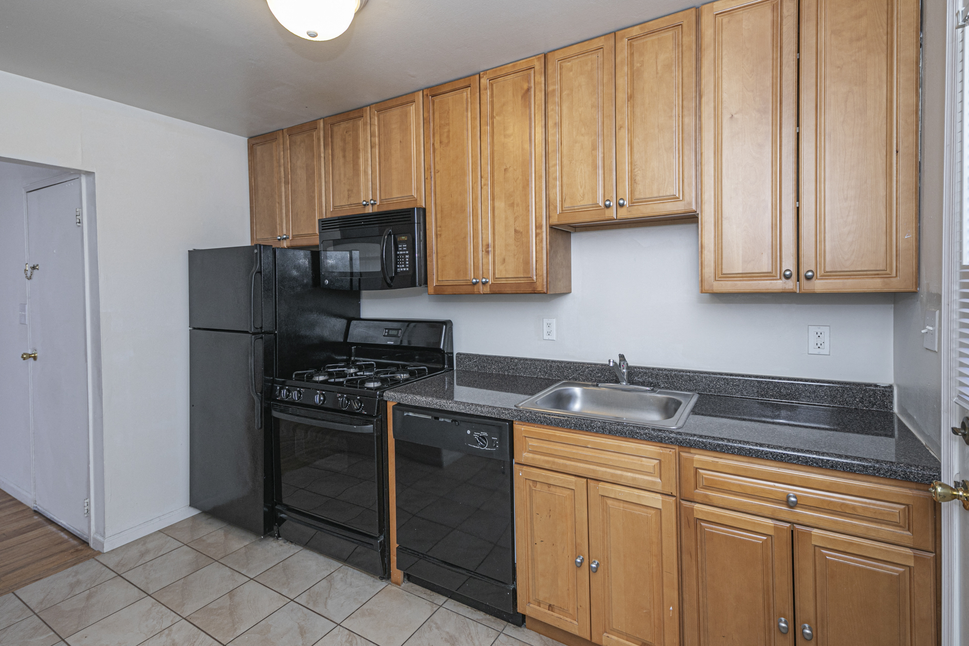 a kitchen with black appliances and wooden cabinets