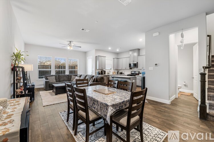 A dining room with a table set for six with a view of the backyard.