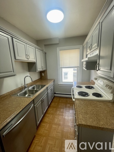 A kitchen with a stove top oven and a sink.