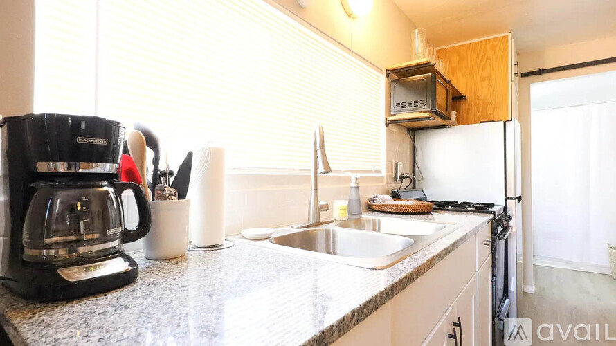 A kitchen with a coffee maker and a sink.