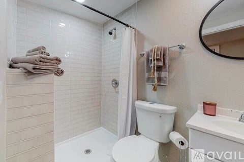 A bathroom with a toilet, sink, and shower.